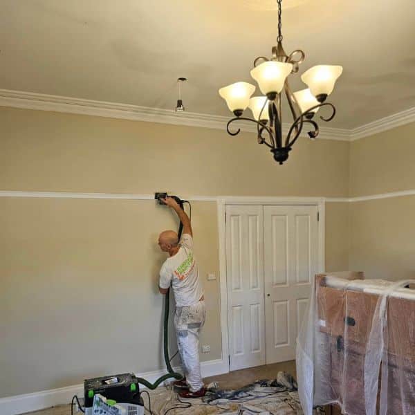 interior and exterior painting - sanding a wall